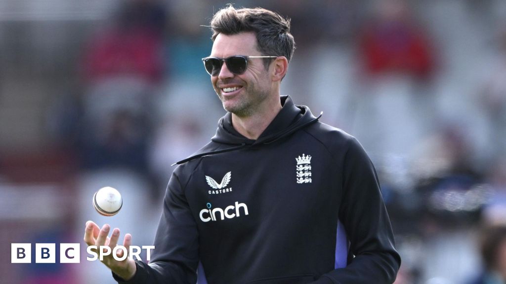 James Anderson tosses a white ball in the air while on coaching duties for England