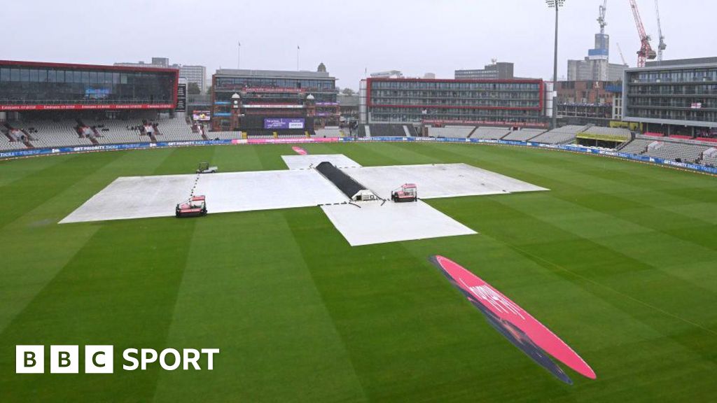 Old Trafford with covers on as rain falls